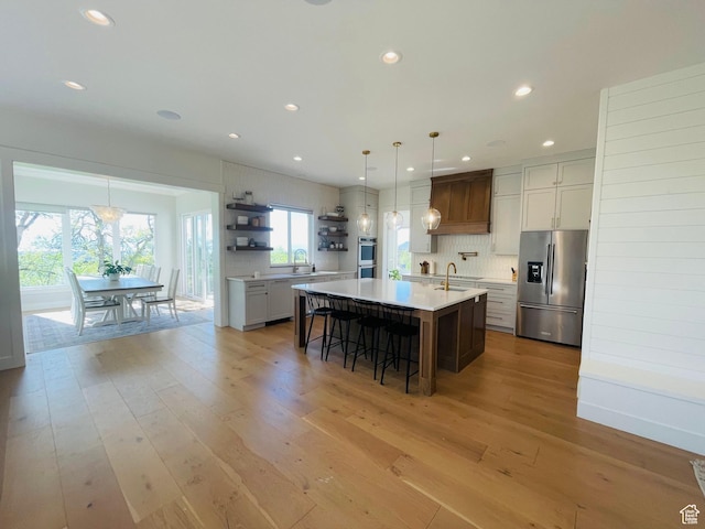 kitchen with stainless steel appliances, tasteful backsplash, open shelves, custom exhaust hood, and light countertops