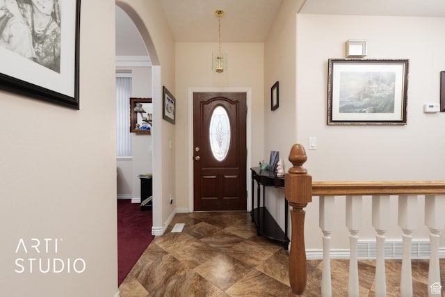 entryway featuring arched walkways and baseboards