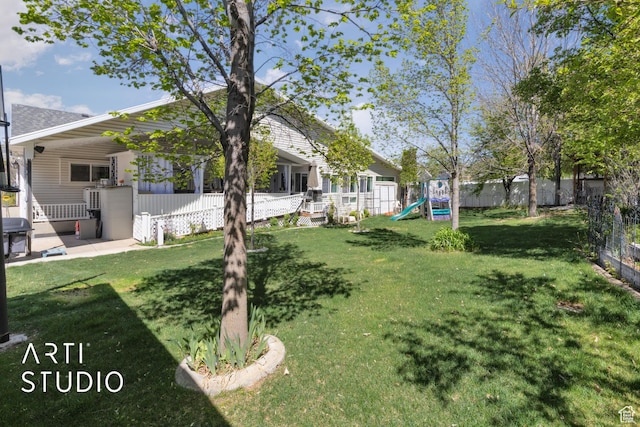 view of yard featuring a playground and fence