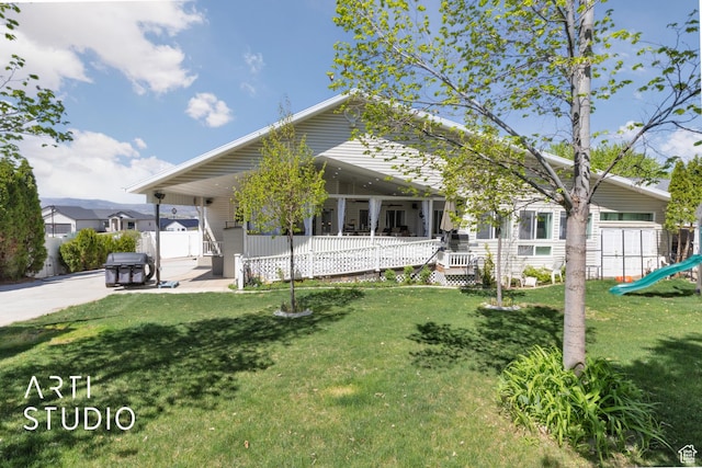 view of front of house featuring a playground, a porch, fence, and a front yard