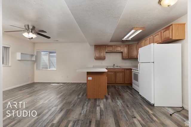 kitchen with light countertops, dark wood-style floors, a sink, and white appliances