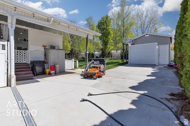 view of patio / terrace featuring an outdoor structure, a detached garage, and fence