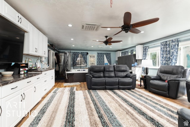 living room featuring ceiling fan, light wood finished floors, and recessed lighting