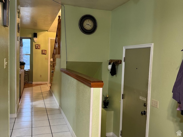 hall with light tile patterned floors and baseboards