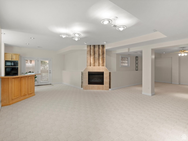 unfurnished living room featuring light carpet, baseboards, a tile fireplace, ceiling fan, and recessed lighting