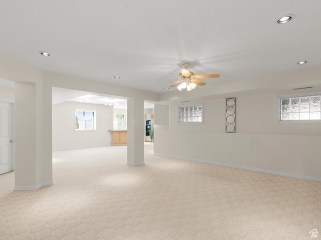 below grade area with light carpet, recessed lighting, a ceiling fan, and baseboards