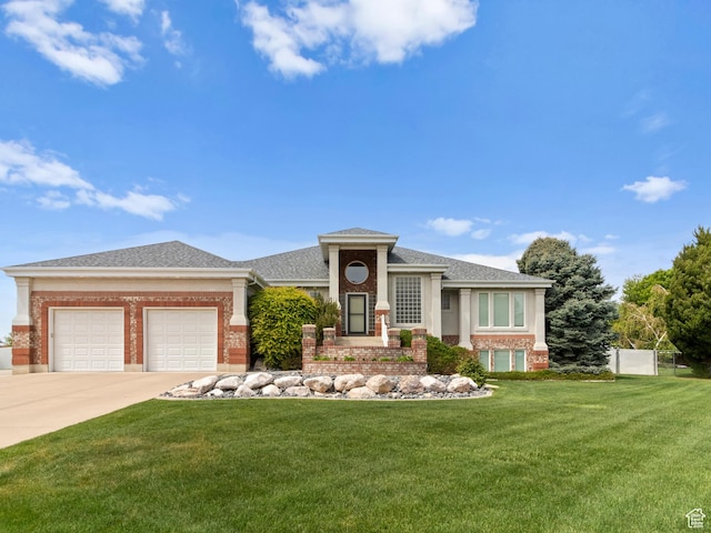 prairie-style home featuring brick siding, a garage, a front yard, concrete driveway, and roof with shingles