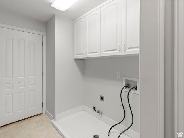 clothes washing area featuring cabinet space, hookup for a gas dryer, hookup for a washing machine, electric dryer hookup, and baseboards