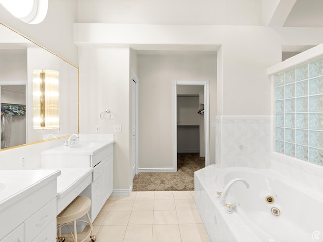 full bath featuring vanity, a whirlpool tub, tile patterned flooring, and a walk in closet