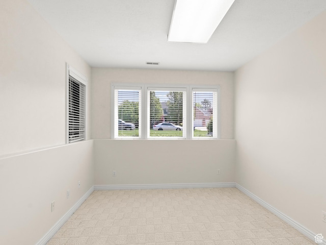 spare room with baseboards and light colored carpet