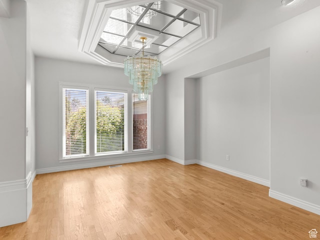 unfurnished dining area with a chandelier, baseboards, and light wood-type flooring