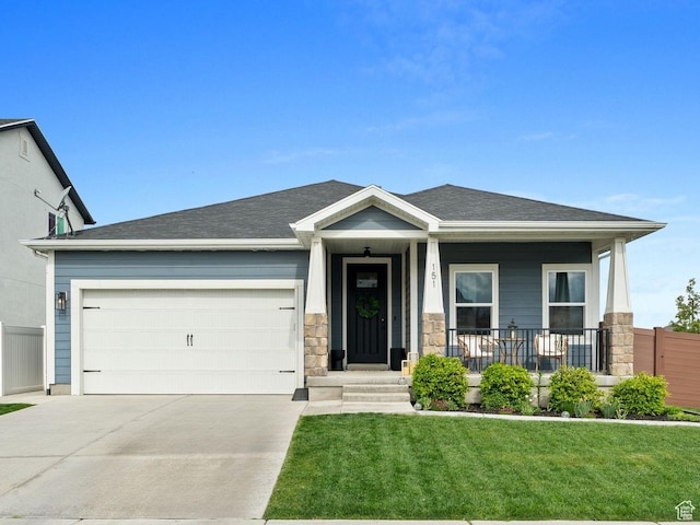 151 N 410th St S, Vineyard, UT 84059 - view of front of home with driveway, a garage, a front yard, stone siding, and covered porch