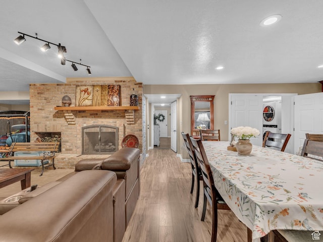 4760 S Meadow Creek Ln E, Ogden, UT 84403 - dining area featuring light wood-style floors, a brick fireplace, stacked washer / dryer, baseboards, and recessed lighting