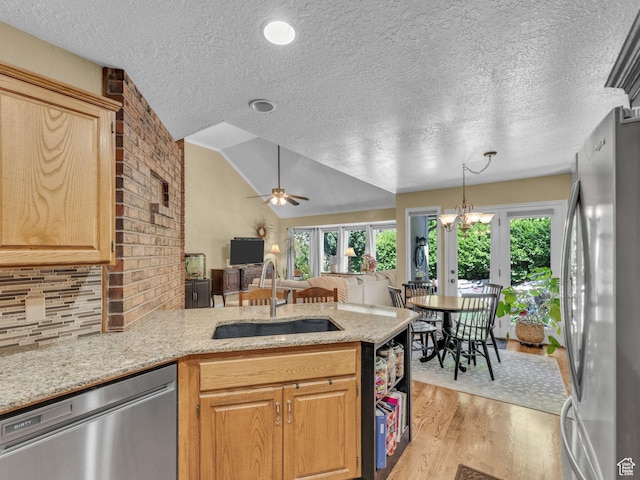4760 S Meadow Creek Ln E, Ogden, UT 84403 - kitchen with appliances with stainless steel finishes, a sink, a peninsula, light wood-style floors, and a textured ceiling