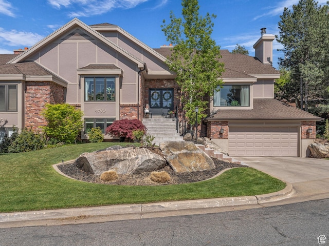 4760 S Meadow Creek Ln E, Ogden, UT 84403 - view of front facade featuring concrete driveway, a front lawn, a garage, a chimney, and brick siding