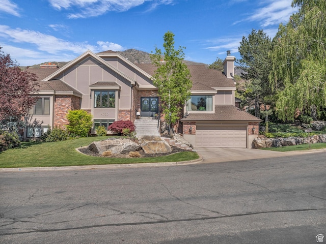 4760 S Meadow Creek Ln E, Ogden, UT 84403 - craftsman inspired home with a chimney, a garage, driveway, a front yard, and brick siding