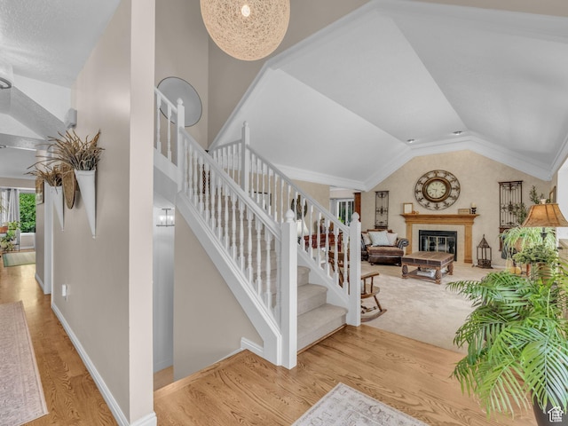 4760 S Meadow Creek Ln E, Ogden, UT 84403 - stairway featuring wood finished floors, lofted ceiling, baseboards, and a tiled fireplace