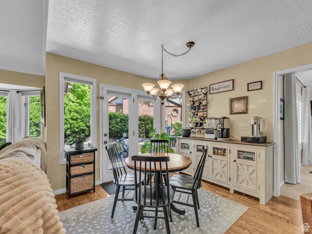 4760 S Meadow Creek Ln E, Ogden, UT 84403 - dining area featuring a textured ceiling, a chandelier, light wood-type flooring, and baseboards