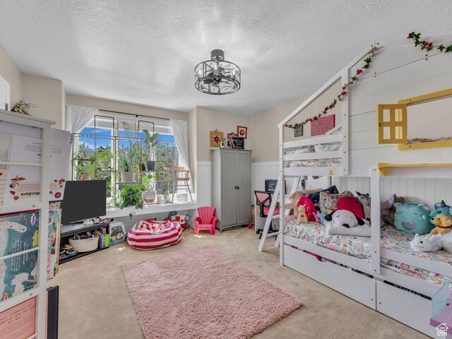 4760 S Meadow Creek Ln E, Ogden, UT 84403 - bedroom featuring a textured ceiling, carpet, a wainscoted wall, a chandelier, and wooden walls
