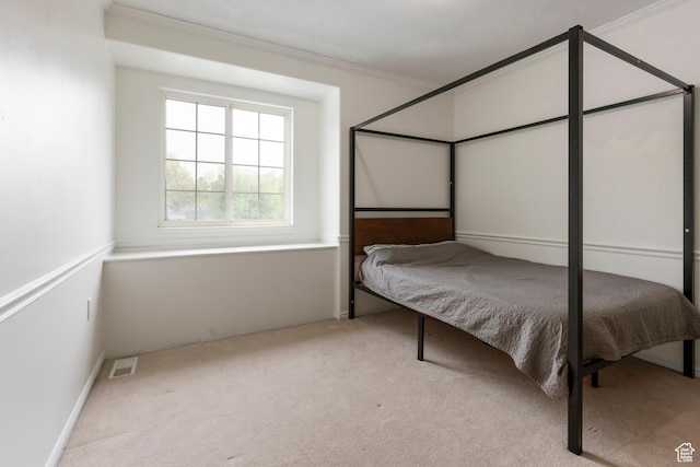 carpeted bedroom with ornamental molding