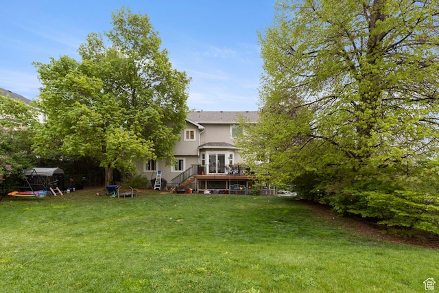 view of green lawn with stairway and a deck