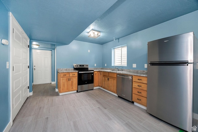 739 N 500 E, Logan, UT 84321 - kitchen featuring stainless steel appliances, light countertops, a sink, a textured ceiling, and baseboards