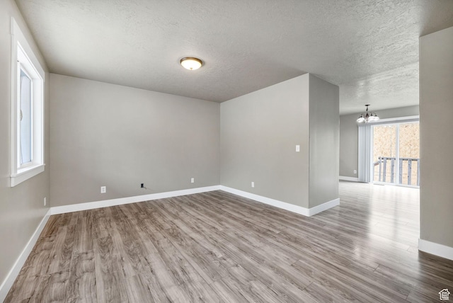 739 N 500 E, Logan, UT 84321 - spare room with a textured ceiling, a chandelier, wood finished floors, and baseboards