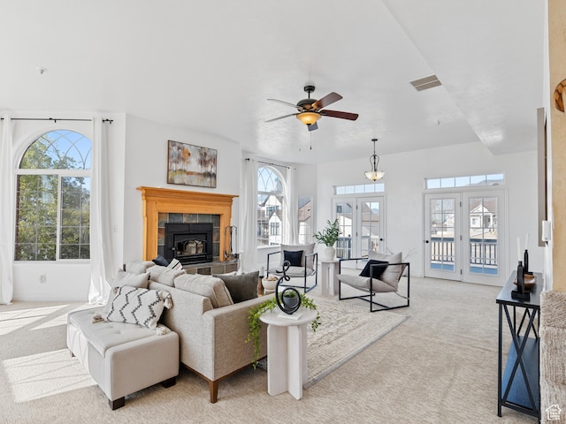 living room featuring light colored carpet, plenty of natural light, french doors, and a ceiling fan