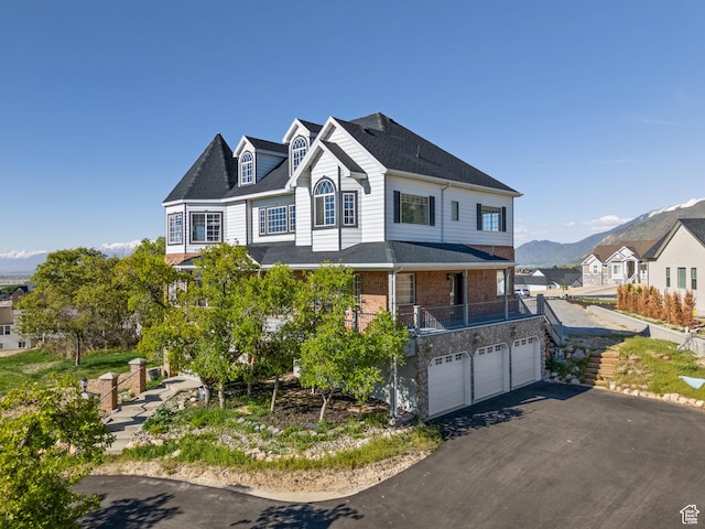 view of front of home featuring an attached garage, driveway, a mountain view, and brick siding