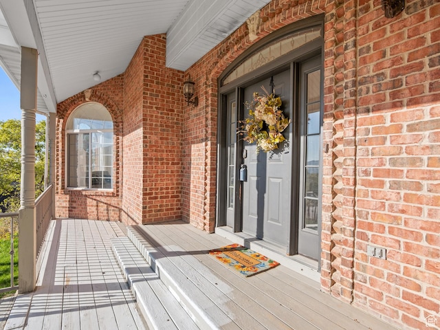 entrance to property with brick siding and covered porch
