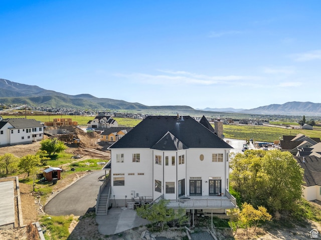 back of property with a chimney and a mountain view