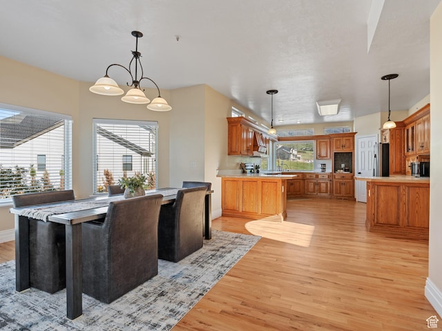 dining space with light wood-style flooring and baseboards