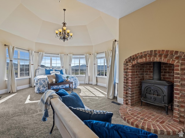 bedroom featuring a chandelier, carpet, baseboards, and a wood stove