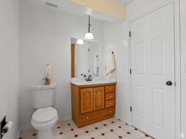 half bath featuring vanity, toilet, baseboards, and tile patterned floors