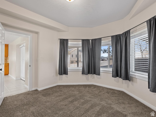 empty room with light carpet and baseboards
