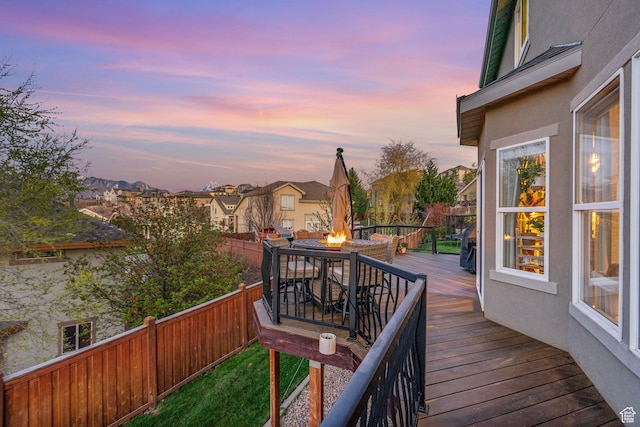 wooden terrace with a fire pit, a fenced backyard, and a residential view