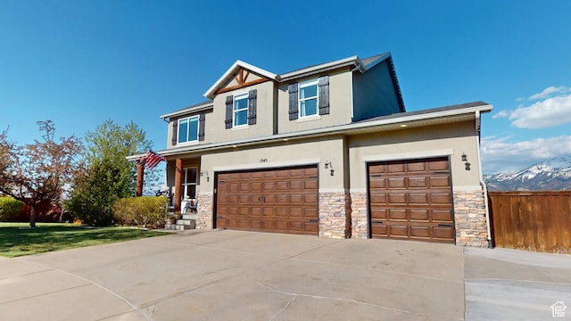 view of front of house with stucco siding, stone siding, an attached garage, and driveway