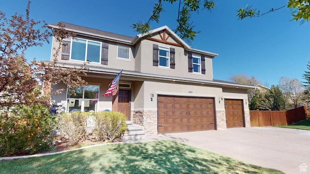 craftsman-style home with stucco siding, a garage, stone siding, driveway, and covered porch