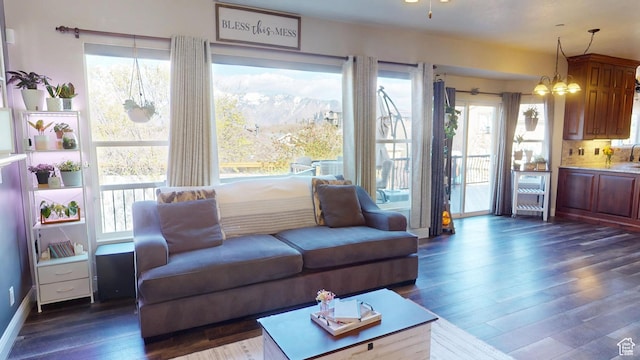 living room with dark wood-type flooring and plenty of natural light