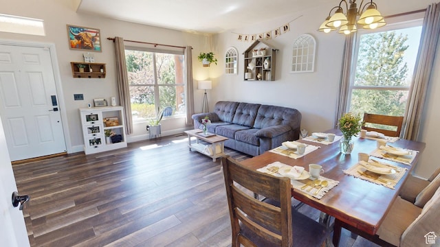 living room with wood finished floors, a chandelier, and baseboards