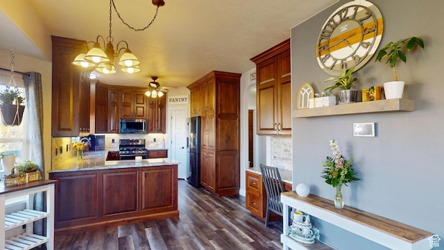 kitchen featuring appliances with stainless steel finishes, decorative backsplash, dark wood-style flooring, and ceiling fan