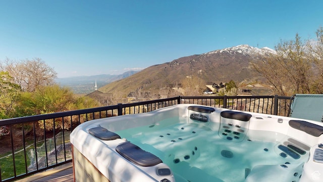 deck featuring a mountain view and a hot tub