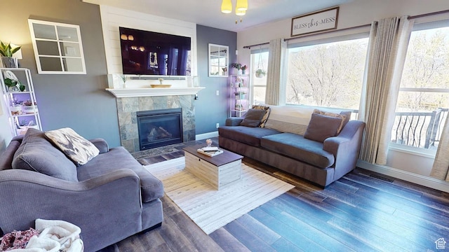 living area featuring wood finished floors, a fireplace, baseboards, and healthy amount of natural light