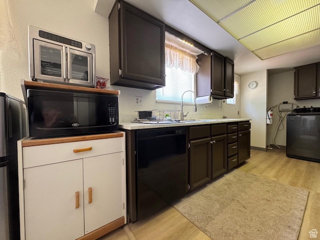 527 W Palisade Dr, Moab, UT 84532 - kitchen featuring black appliances, washer / clothes dryer, light wood-type flooring, and light countertops