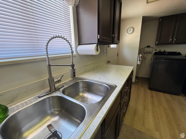 527 W Palisade Dr, Moab, UT 84532 - kitchen with washer / clothes dryer, wood finished floors, light stone countertops, and dark brown cabinets