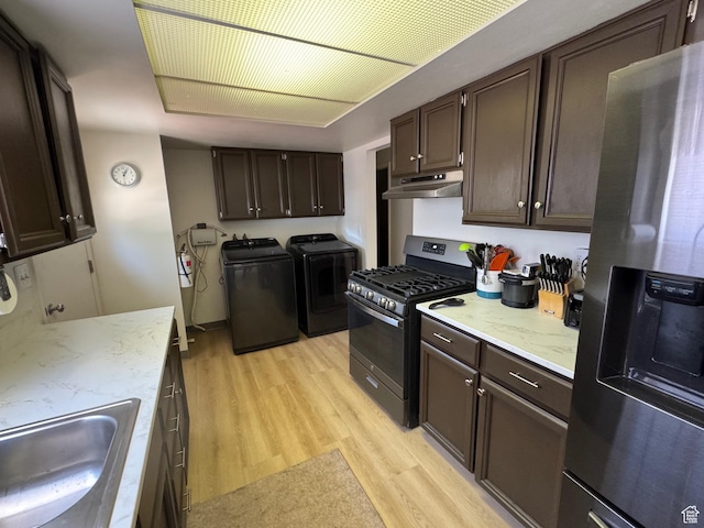 527 W Palisade Dr, Moab, UT 84532 - kitchen featuring stainless steel fridge, washing machine and clothes dryer, gas stove, under cabinet range hood, and light wood-style floors