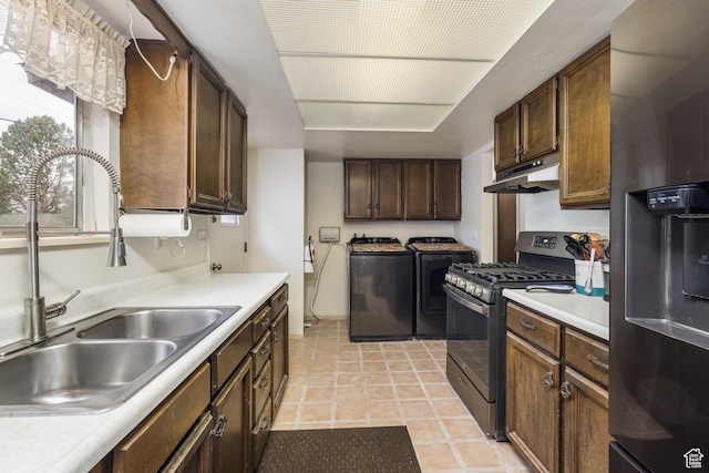 527 W Palisade Dr, Moab, UT 84532 - kitchen featuring washer and dryer, fridge with ice dispenser, stainless steel gas range oven, a sink, and light countertops