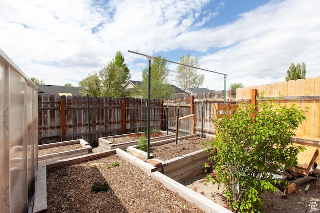 fenced backyard featuring a garden