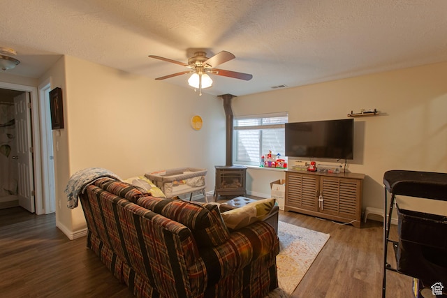 living room featuring wood finished floors, ceiling fan, baseboards, and a textured ceiling