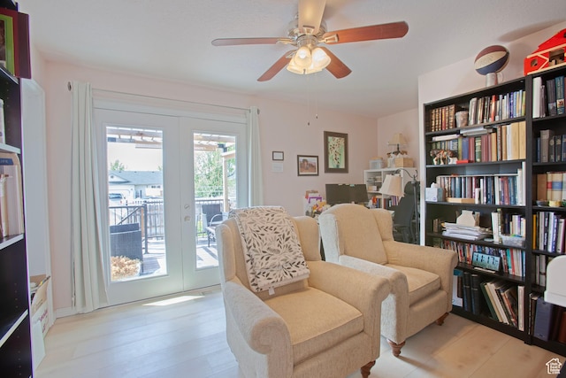 sitting room with french doors, ceiling fan, and wood finished floors